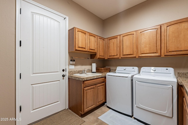 clothes washing area featuring cabinet space, washer and clothes dryer, and a sink