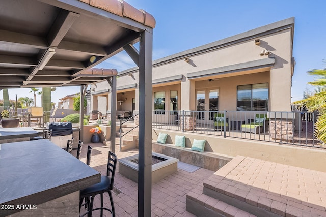 view of patio / terrace with outdoor dry bar, an outdoor fire pit, and outdoor dining space