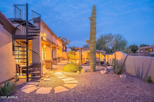 view of yard featuring a patio, stairway, and fence