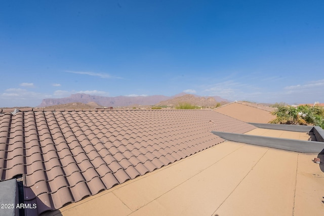 exterior space featuring a tile roof and a mountain view