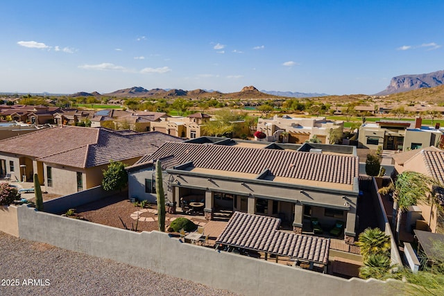 view of front of house featuring a patio area, a residential view, a mountain view, and a tiled roof