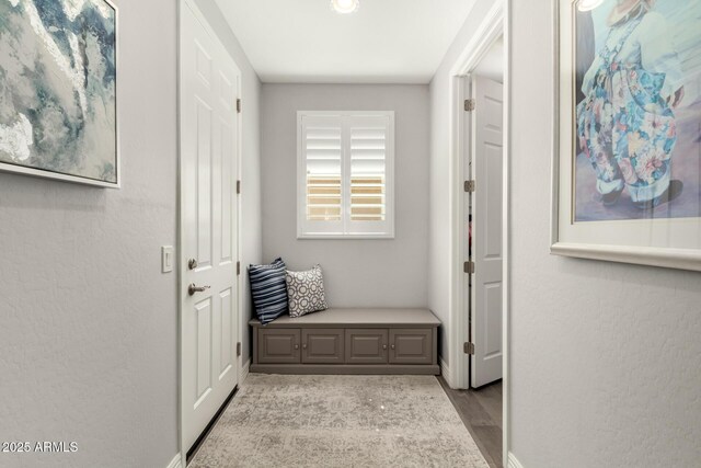 corridor with wood finished floors and baseboards