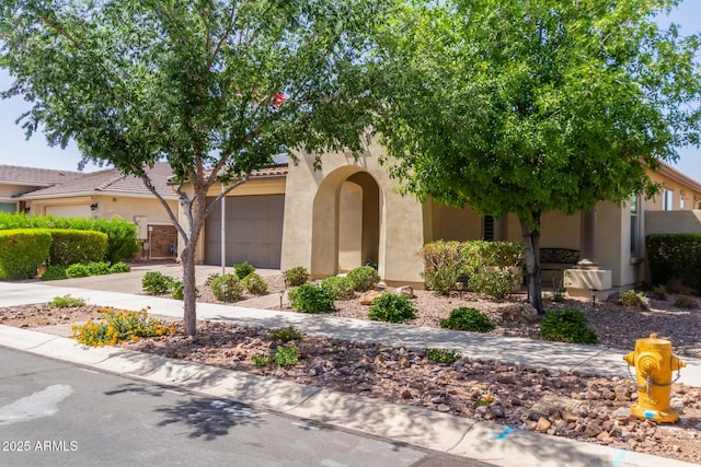 view of front facade with concrete driveway, stucco siding, and a garage
