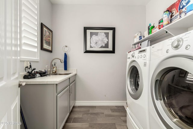 laundry room featuring independent washer and dryer, baseboards, wood finished floors, and cabinet space