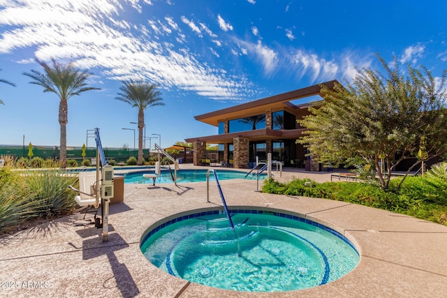 community pool with a hot tub and a patio