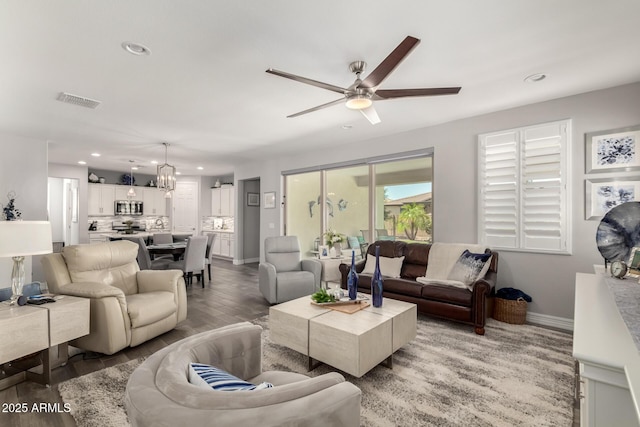living room featuring baseboards, ceiling fan, recessed lighting, and light wood finished floors