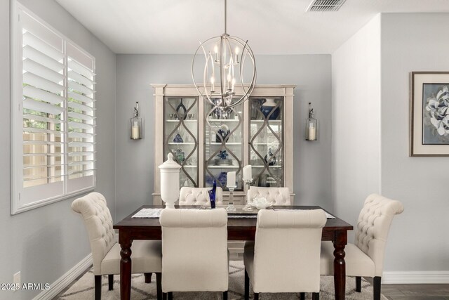 dining space with a chandelier and baseboards