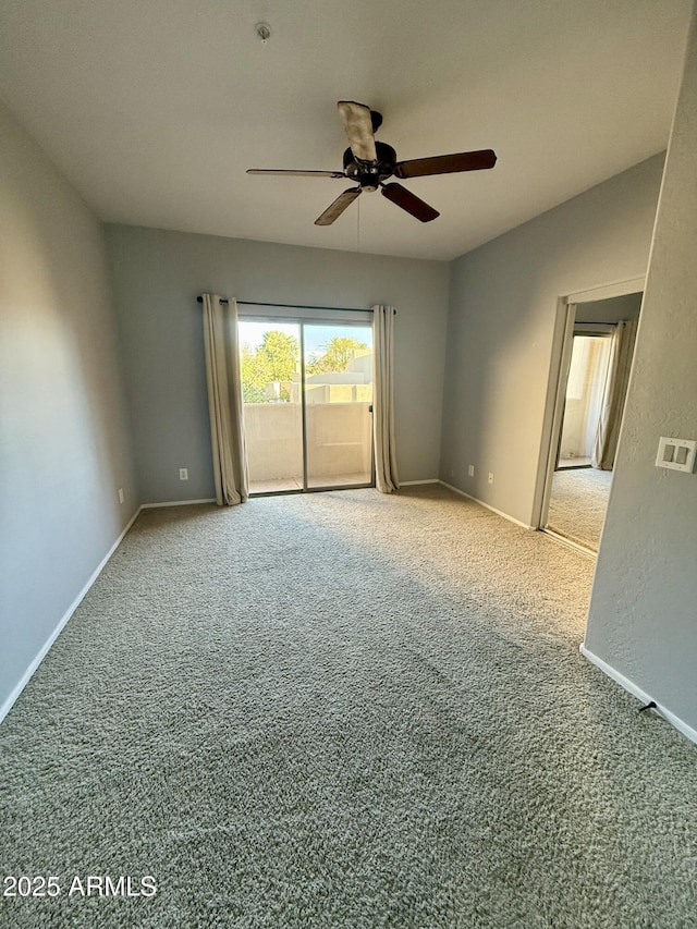 empty room featuring carpet, a ceiling fan, and baseboards