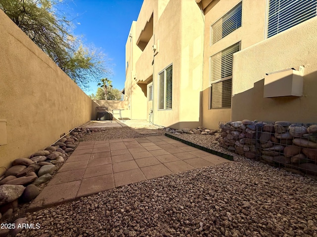 exterior space featuring stucco siding, a patio, central AC unit, and fence