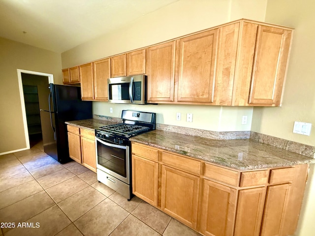 kitchen featuring stainless steel appliances, light tile patterned flooring, and stone countertops