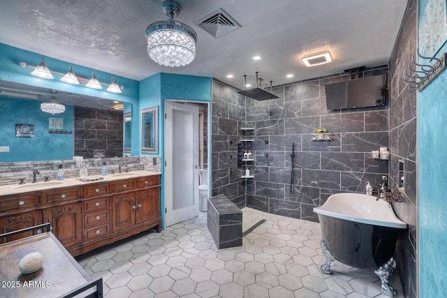 bathroom with a sink, an inviting chandelier, walk in shower, and visible vents