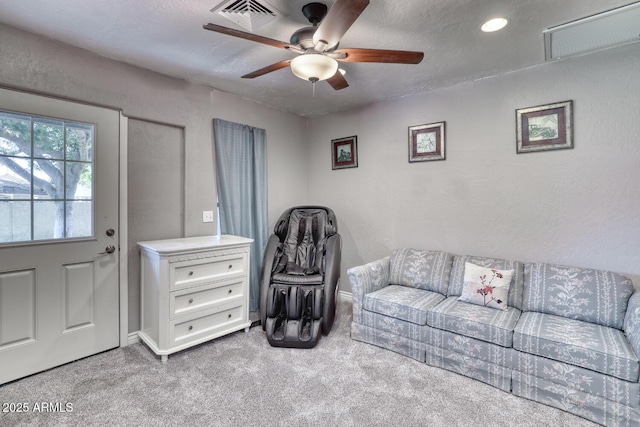 living room with a ceiling fan, carpet flooring, and visible vents