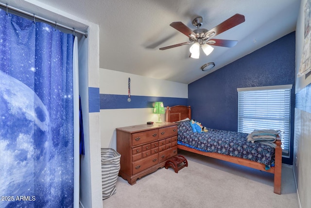 carpeted bedroom with a ceiling fan and vaulted ceiling