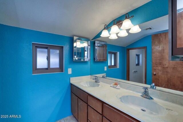 bathroom featuring vaulted ceiling, a wealth of natural light, and a sink