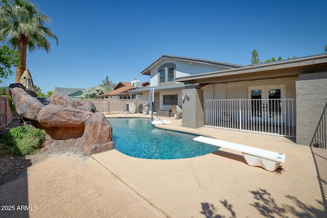 view of pool featuring a patio, a diving board, fence, and a fenced in pool