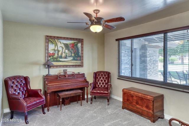 living area with carpet floors, a ceiling fan, and baseboards