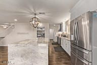 28422 N 32nd Ln, Phoenix, AZ 85083 - kitchen featuring light stone counters, a kitchen island, white cabinetry, freestanding refrigerator, and pendant lighting