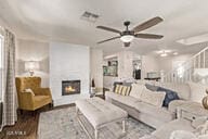 28422 N 32nd Ln, Phoenix, AZ 85083 - living room featuring a warm lit fireplace, ceiling fan, visible vents, and wood finished floors