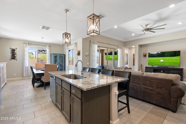 15663 S 183rd Dr, Goodyear, AZ 85338 - kitchen with a sink, open floor plan, visible vents, a kitchen bar, and dishwasher