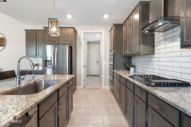 15663 S 183rd Dr, Goodyear, AZ 85338 - kitchen with light stone counters, dark brown cabinets, a sink, wall chimney exhaust hood, and appliances with stainless steel finishes
