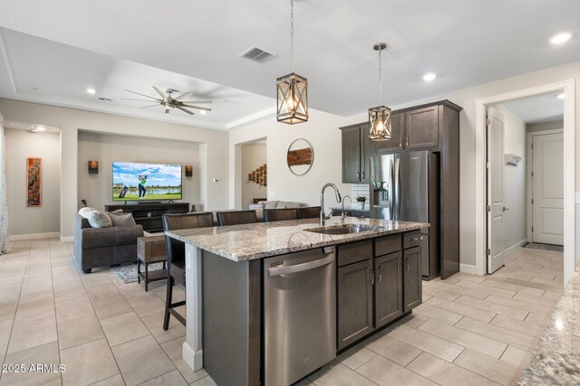 15663 S 183rd Dr, Goodyear, AZ 85338 - kitchen featuring stainless steel appliances, visible vents, a sink, light stone countertops, and open floor plan