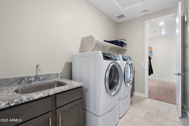 15663 S 183rd Dr, Goodyear, AZ 85338 - washroom featuring a sink, separate washer and dryer, light tile patterned flooring, light colored carpet, and visible vents