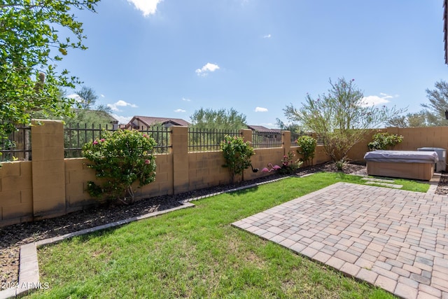 view of yard featuring a patio area, a fenced backyard, and a hot tub