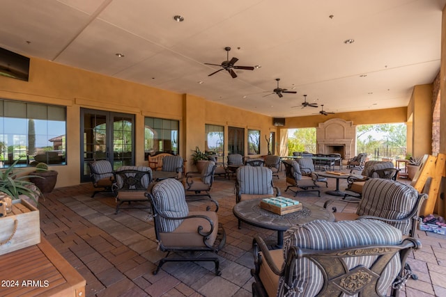 view of patio / terrace with a ceiling fan and an outdoor living space with a fireplace