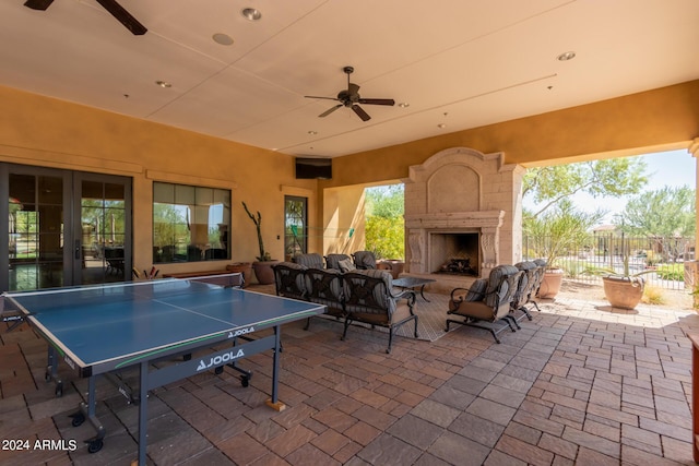 view of patio / terrace featuring an outdoor living space with a fireplace, ceiling fan, and fence