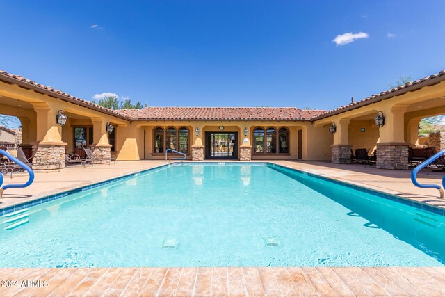 view of swimming pool featuring a community hot tub and a patio area