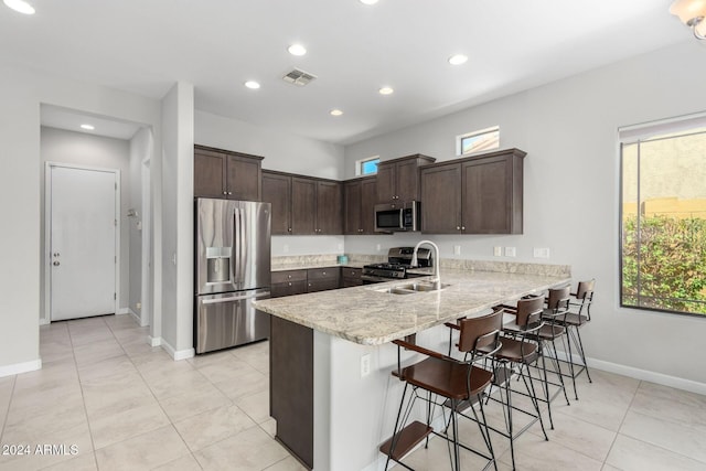 kitchen featuring stainless steel appliances, plenty of natural light, a peninsula, and visible vents