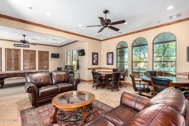 living room featuring ceiling fan, ornamental molding, and a wealth of natural light