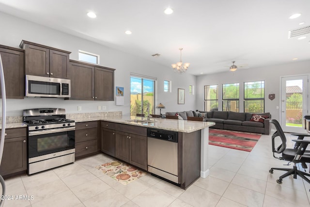kitchen with visible vents, a peninsula, a sink, dark brown cabinetry, and appliances with stainless steel finishes