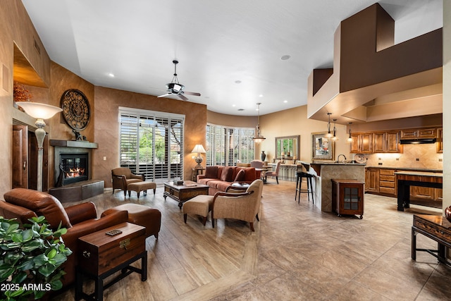 living area featuring ceiling fan, a fireplace, and recessed lighting