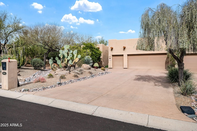 southwest-style home featuring concrete driveway, an attached garage, and stucco siding