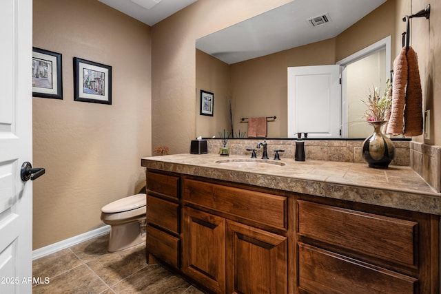 bathroom with tile patterned flooring, toilet, vanity, visible vents, and baseboards