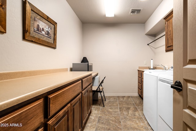 laundry area with cabinet space, baseboards, visible vents, separate washer and dryer, and a sink