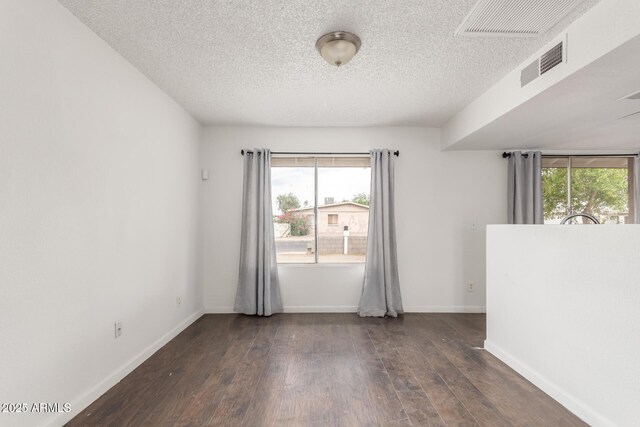 3042 N 87th Ave, Phoenix, AZ 85037 - unfurnished room featuring plenty of natural light, wood finished floors, a textured ceiling, and baseboards