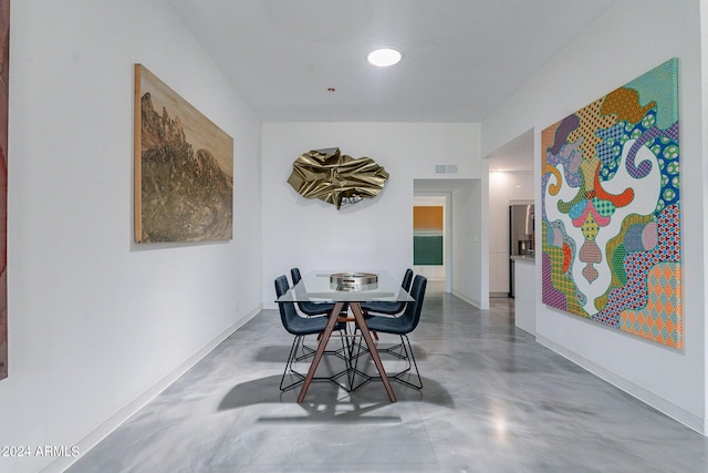 dining space featuring concrete floors