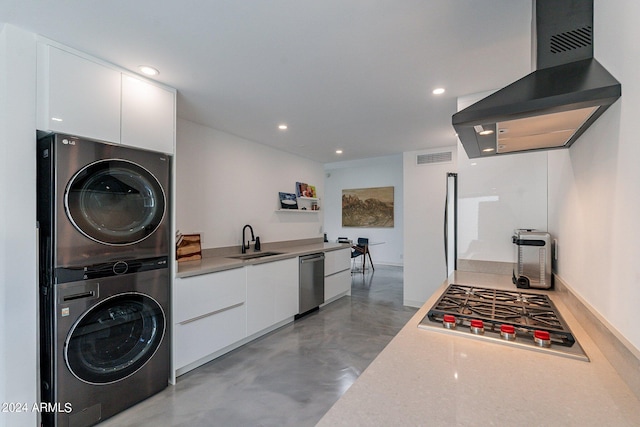 laundry area featuring stacked washer and dryer and sink