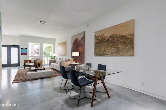 dining area featuring concrete flooring and french doors