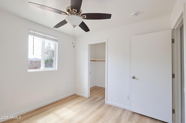751 E Southern Ave, Phoenix, AZ 85040 - unfurnished bedroom featuring a spacious closet, a closet, baseboards, and light wood finished floors