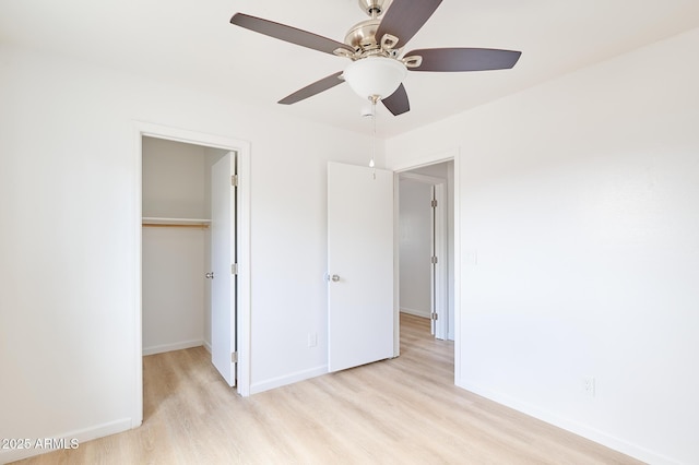 751 E Southern Ave, Phoenix, AZ 85040 - unfurnished bedroom featuring light wood-type flooring, baseboards, a closet, a spacious closet, and ceiling fan