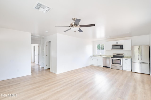 751 E Southern Ave, Phoenix, AZ 85040 - kitchen featuring visible vents, white cabinets, light countertops, stainless steel appliances, and light wood-style flooring