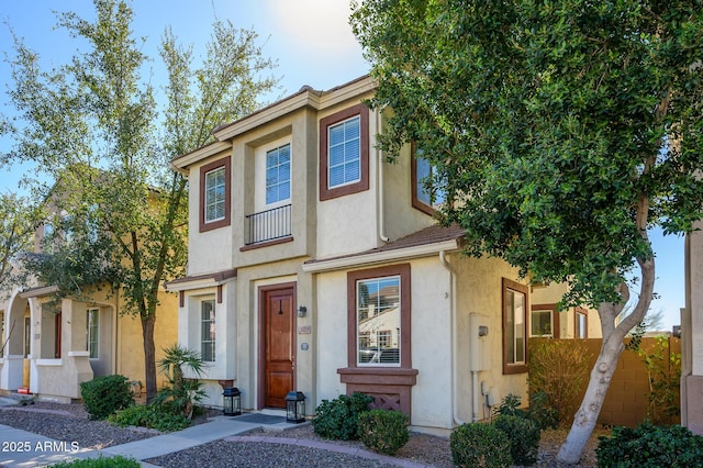 view of property with stucco siding and fence