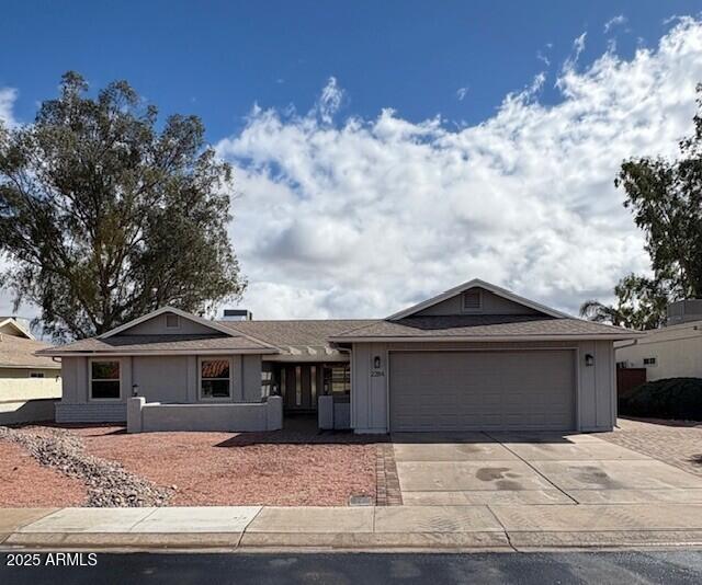 ranch-style house with a garage and driveway