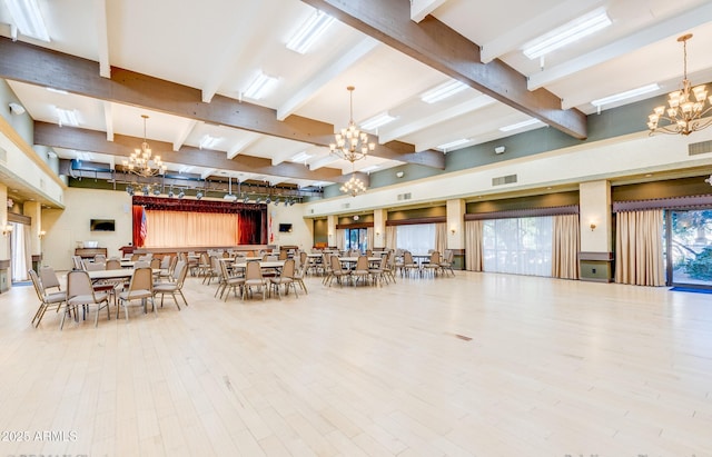 interior space with a chandelier, beam ceiling, and wood finished floors