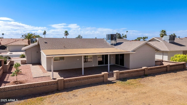 rear view of property featuring a shingled roof, central AC, a fenced backyard, and a patio area