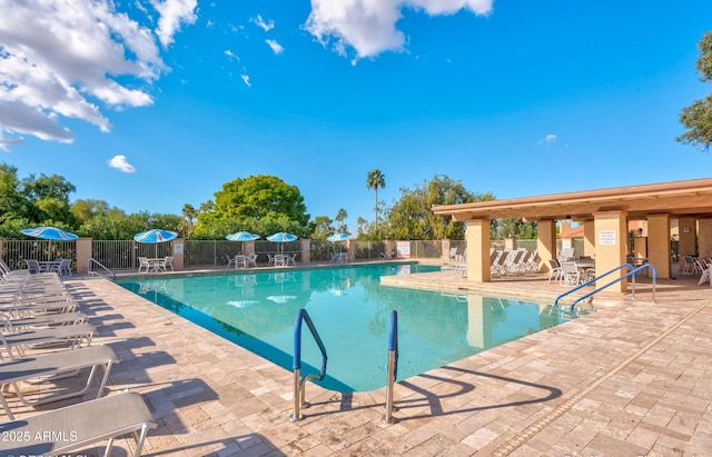 community pool with a patio and fence