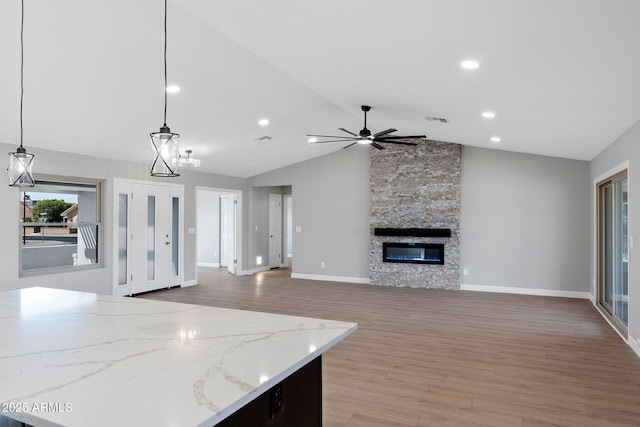 kitchen featuring decorative light fixtures, visible vents, light wood-style flooring, and a fireplace